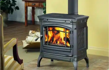 specials-fireplace-stove-3 Cast-iron wood stove glowing with a fire in a cozy living room.